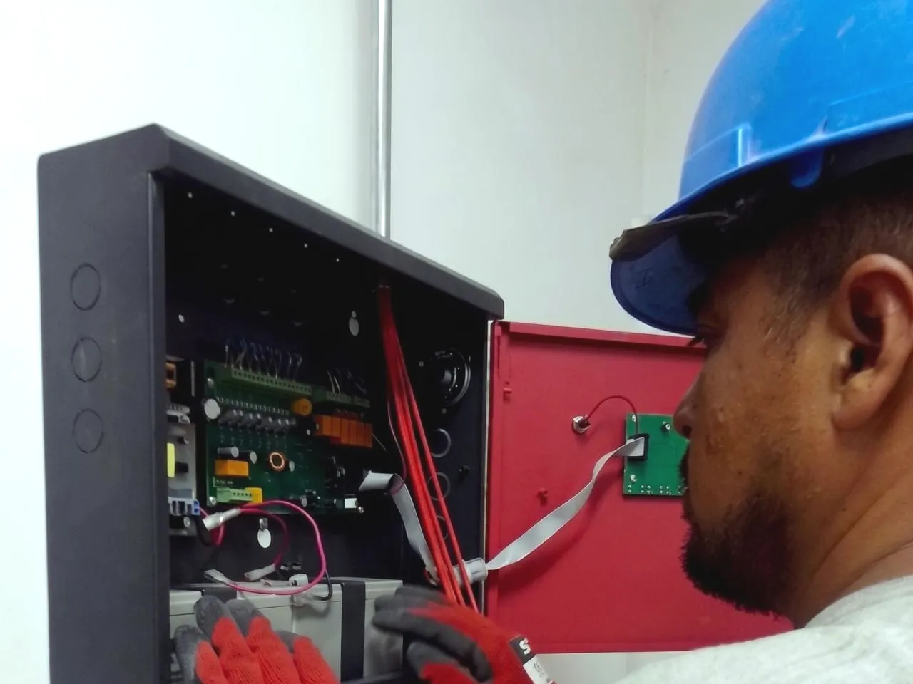 Técnico cableando la central de detección y alarma contra incendios dentro de su gabinete
