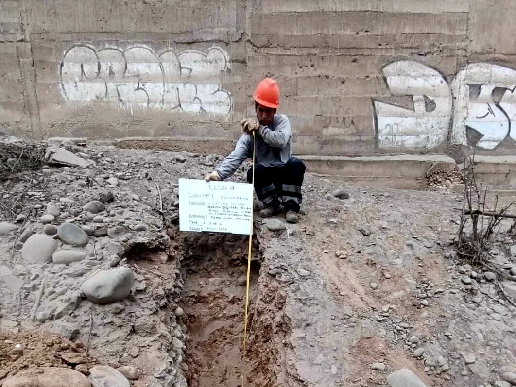 Excavación de un pozo a tierra con la wincha de medición dentro y el cartel de identificación de la obra