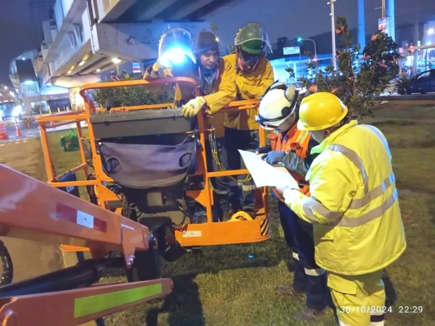Cuadrilla revisando el plan de trabajo junto a un elevador articulado durante una intervención nocturna