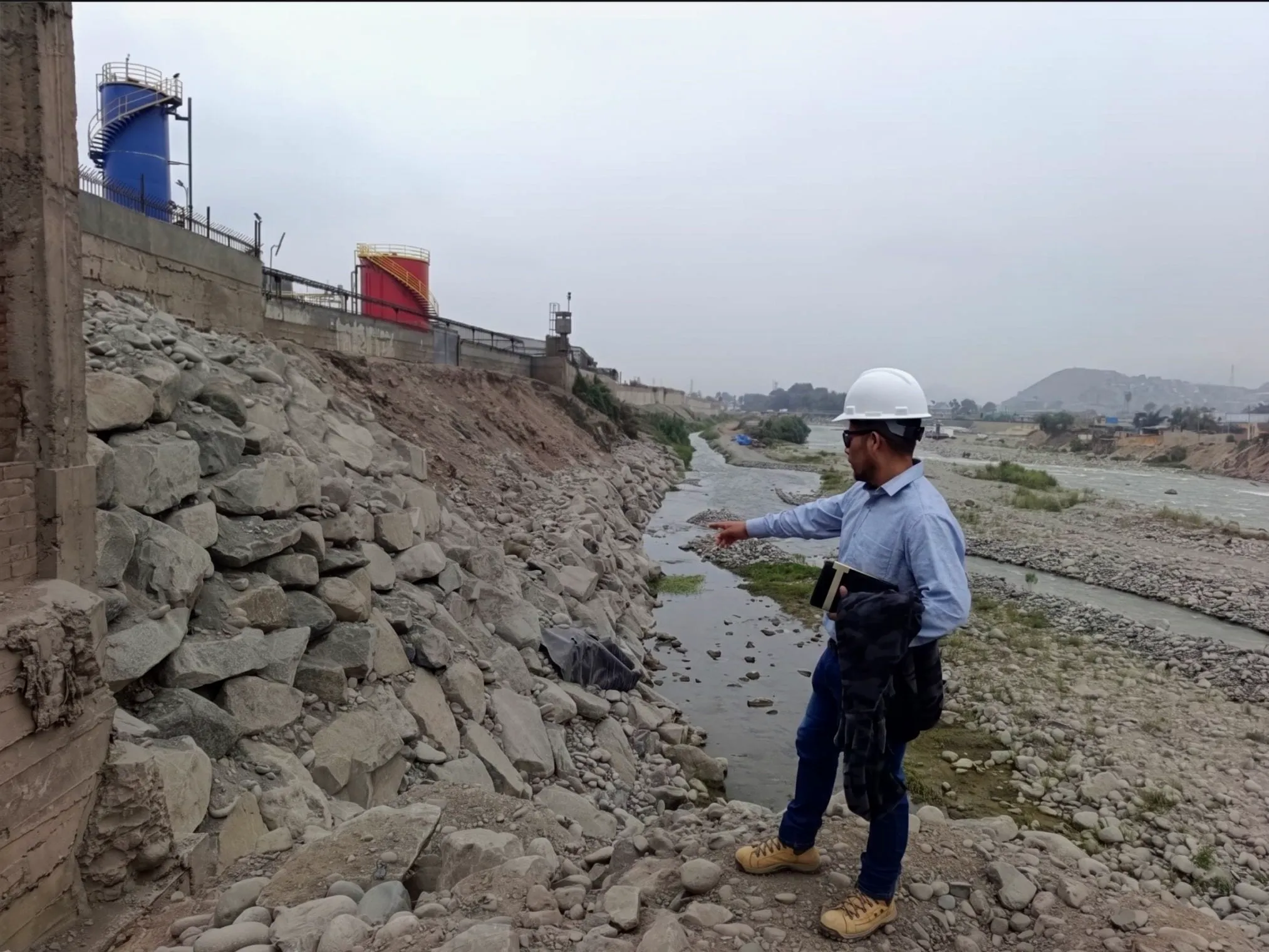 Ingeniero supervisando el enrocado de una defensa ribereña a orillas del río Rímac