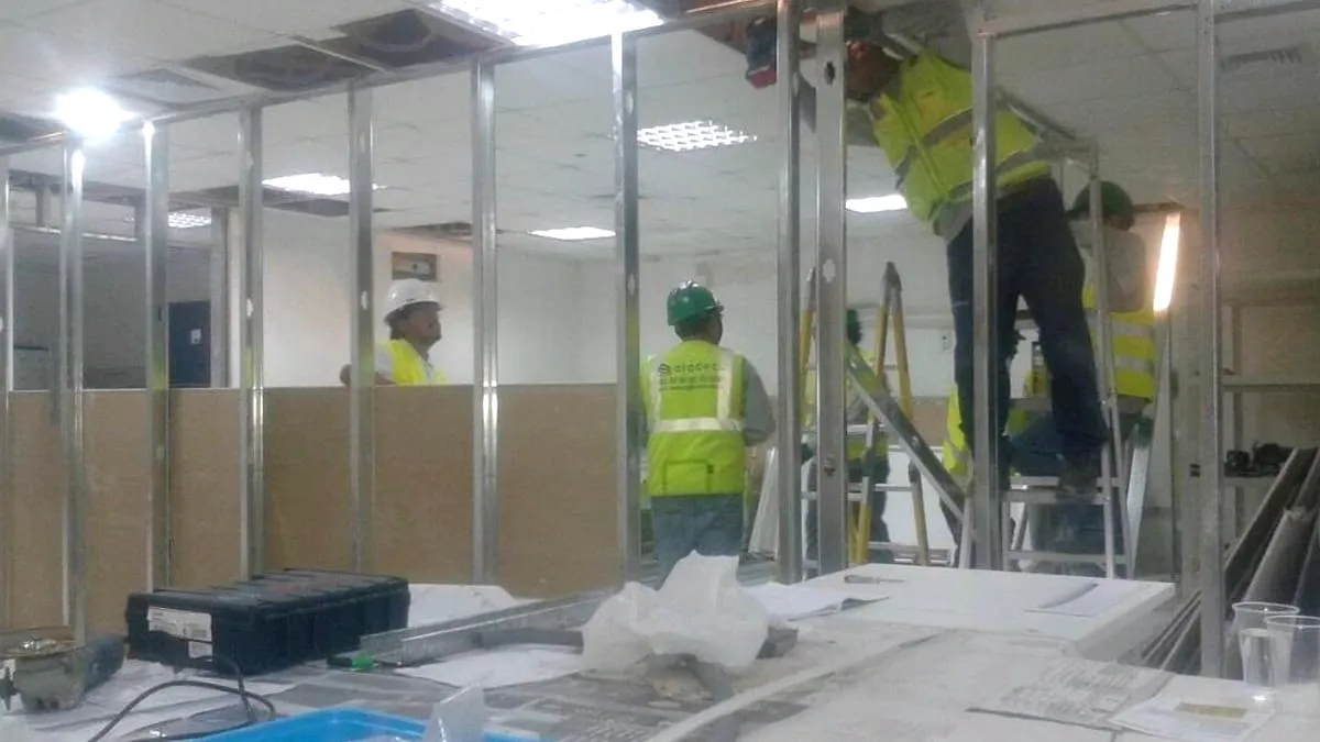 Oficina en obra con la tabiquería de perfilería metálica y las mamparas de vidrio ya montadas